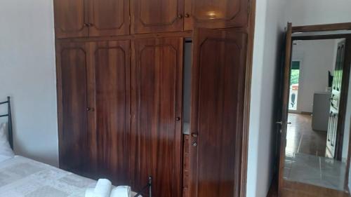 a wooden cabinet in a bedroom with a mirror at family home in Kanálion