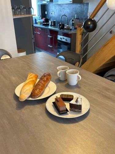 2 assiettes de pain et de viennoiseries sur une table dans l'établissement Bella casita, à Dunkerque