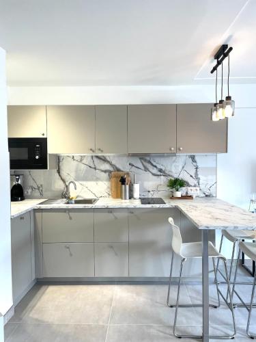 une cuisine avec des armoires blanches et une table dans l'établissement Suite élégante et moderne Cannes centre, à Cannes