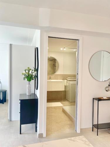 La salle de bains est pourvue d'une porte en verre menant à une baignoire. dans l'établissement Suite élégante et moderne Cannes centre, à Cannes