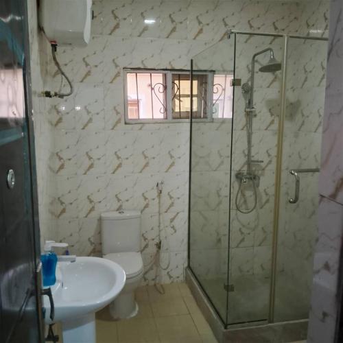 a bathroom with a shower and a toilet and a sink at Peace in Lekki