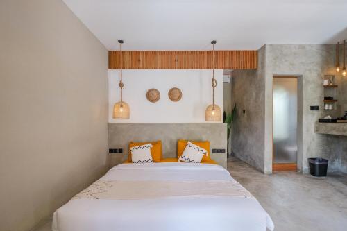 Un dormitorio con una gran cama blanca con almohadas naranjas. en Modern Uluwatu Studio Apartment and Pool, en Uluwatu