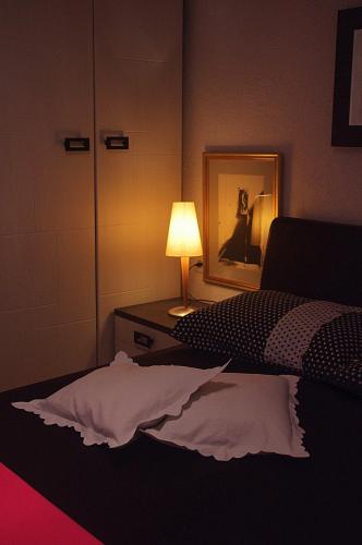 a bedroom with a bed and a lamp and a mirror at Apartments Lux in Makarska