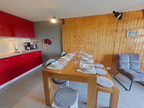 - une table en bois avec des assiettes dans la cuisine dans l'établissement Appartement cosy avec cheminée et balcon, 6 couchages, Le Grand-Bornand - FR-1-241-63, au Grand-Bornand
