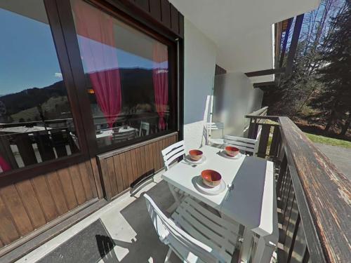 un porche avec une table et des chaises sur un balcon dans l'établissement Studio cosy 4 pers. au Grand-Bornand, navette proche, parking, ménage inclus - FR-1-241-141, au Grand-Bornand