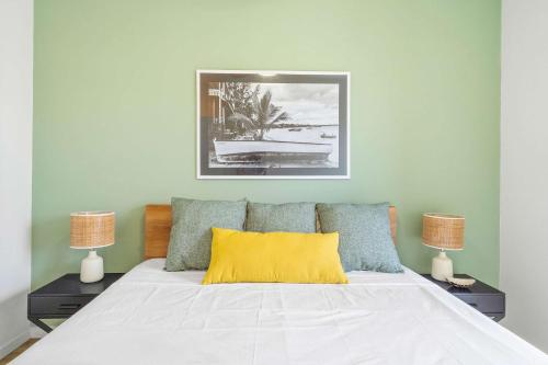 a bedroom with a bed with a yellow pillow on it at Azuri by Sealodge - Amazing Seaview Apartment in Roches Noires