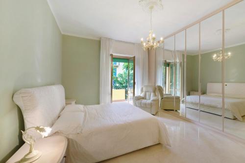 a bedroom with a white bed and a mirror at Casa Nonna Adri in Levanto