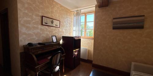 a living room with a piano and a window at Manoir Des Douets Fleuris in Cancale