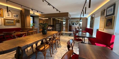 a restaurant with a large wooden table and chairs at Manoir Des Douets Fleuris in Cancale