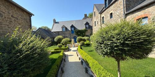 a garden in front of a building with trees at Manoir Des Douets Fleuris in Cancale