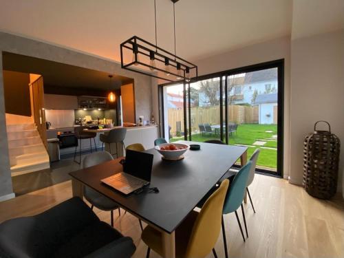 une salle à manger et une cuisine avec une table avec un ordinateur portable dans l'établissement Magnifique villa Quartier Benoît, 200m de la plage, à La Baule