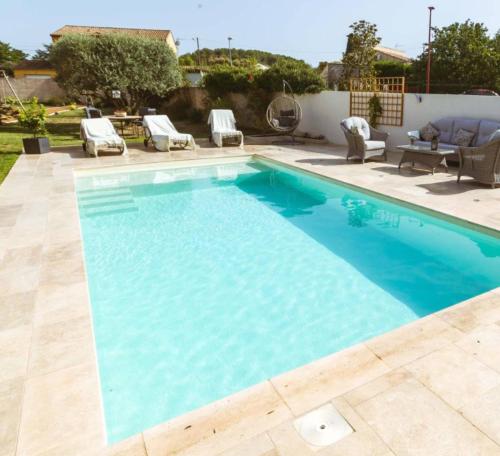 a swimming pool with blue water in a yard at Hype B in Sétif
