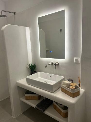 un bagno bianco con lavandino e specchio di Almires 1-Stay 20m from Aegean Sea a Cherronisos