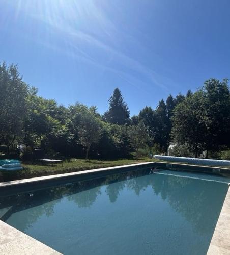une piscine avec de l'eau bleue dans une cour dans l'établissement Au Pré Fleuri Eco Glamping, à Le Lindois