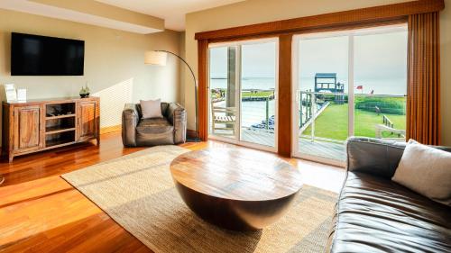 a living room with a couch and a table at Kite Point - Waterfront 2-Bedroom, 2-Bathroom Suite at REAL Watersports in Waves