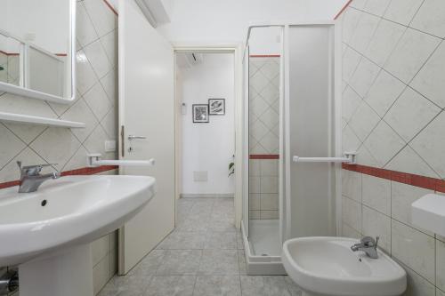 a white bathroom with a sink and a shower at Fra in Calasetta