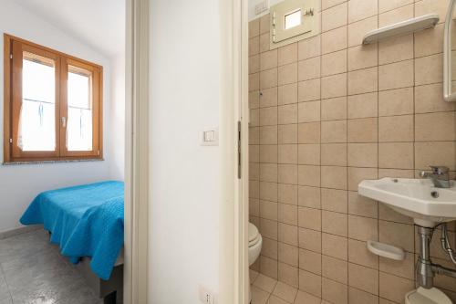 a bathroom with a sink and a toilet and a window at Cri in Calasetta