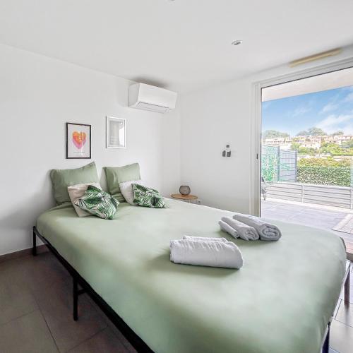 - une chambre avec un grand lit vert et une fenêtre dans l'établissement Havre de paix avec terrasse, à La Gaude