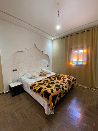 a bedroom with a bed with a cow patterned blanket at Villa cherif in Chouiter