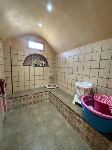 a tiled bathroom with a tub and a sink at Villa cherif in Chouiter