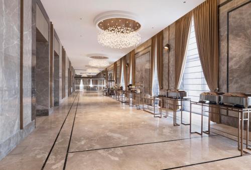 a long hallway with tables and a chandelier at Crowne Plaza Lucknow by IHG in Lucknow