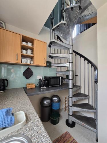 a kitchen with a spiral staircase in a room at The Loft at Box Bridge in Brecon