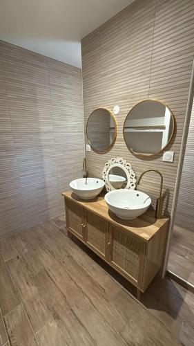 a bathroom with two sinks and two mirrors at Catiwito in Cours-de-Pile