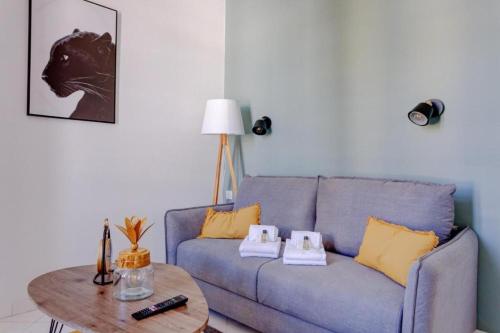 un salon avec un canapé bleu et une table dans l'établissement LA PANTHERE studio design central et calme, idéal pour un séjour en couple ou congrès, à Cannes