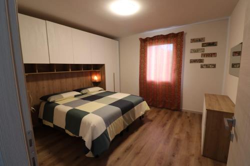a bedroom with a bed with a black and white blanket at Appartamento al Sole in Paderno del Grappa