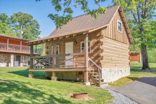a log cabin with a porch and a house at Cozy Log Cabin Retreat in Tennessee in Pigeon Forge