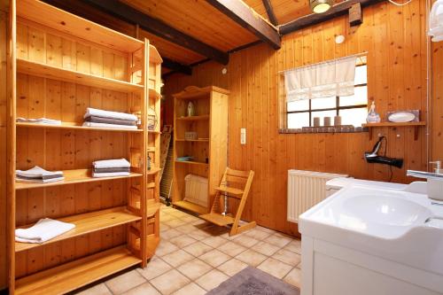 a bathroom with wooden walls and a sink and a counter at Alfreds Landidyll in Weddingstedt