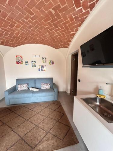 a living room with a blue couch and a sink at Ermitage la suite-hermitage al tramonto-Hermitage tra le vigne in Cioccaro