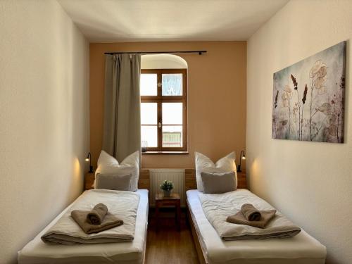 two beds in a room with a window at Gassentraum NEU mit Balkon in Pirna