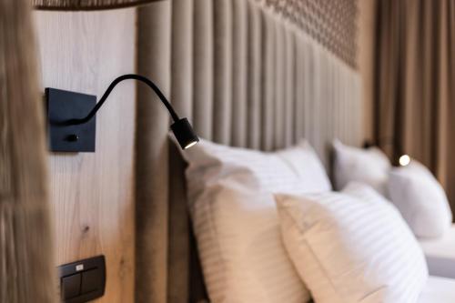 a lamp on the side of a bed with pillows at Hotel Julian Alps in Zgornje Gorje