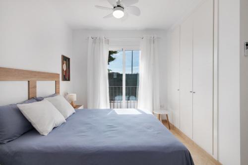 a bedroom with a blue bed and a window at Estrella in Ayamonte