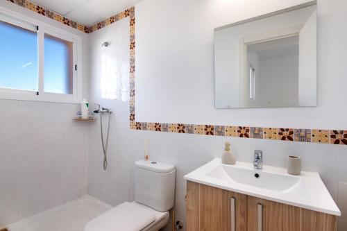 a bathroom with a toilet and a sink and a mirror at Estrella in Ayamonte
