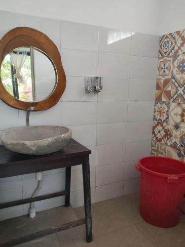 a bathroom with a sink and a mirror on a table at Kahyangan hotel in Dondo