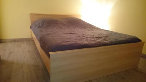 een bed met een houten frame in een kamer bij Le Miracle in Lédenon