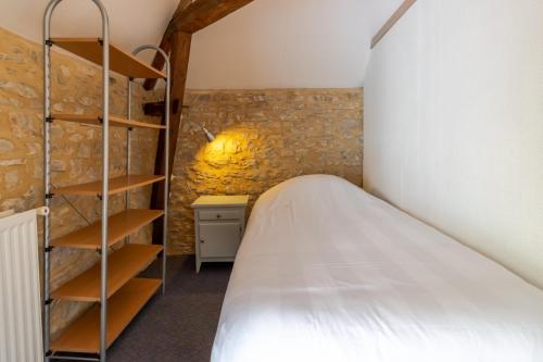 a bedroom with a bed and a book shelf at Maison Salle de Musique in La Forge-dʼAns