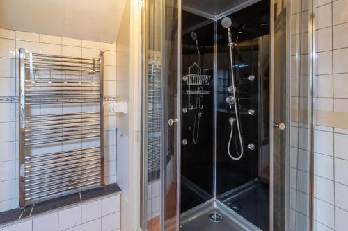 a shower with a glass door in a bathroom at Maison Salle de Musique in La Forge-dʼAns