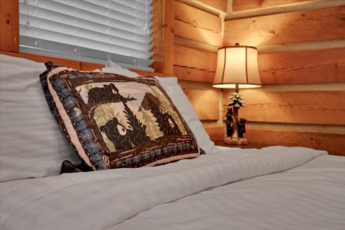 a bedroom with a bed with a pillow and a lamp at Studio Cabin with Loft near Smoky Mountains in Pigeon Forge