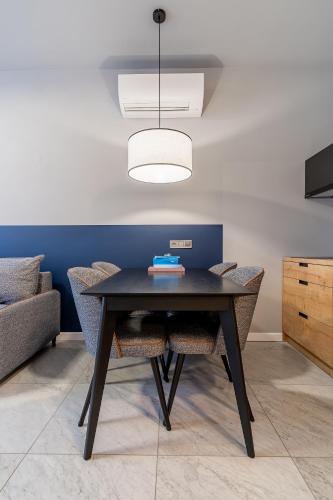 a dining room with a black table and chairs at H11 Aparthotel in Kraków