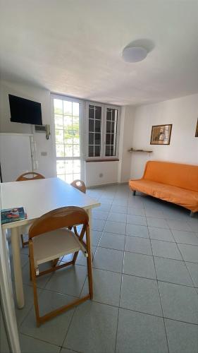 a living room with an orange couch and a table at Villa Conti Residence in Lacona