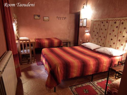 a hotel room with two beds and a table at Hotel Tomboctou in Tinerhir