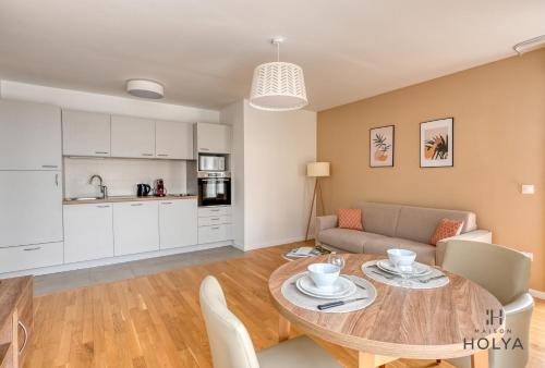 une cuisine et un salon avec une table et un canapé dans l'établissement Appartements pour 2, 4, ou 5 personnes - Clichy - Proche Paris, à Clichy