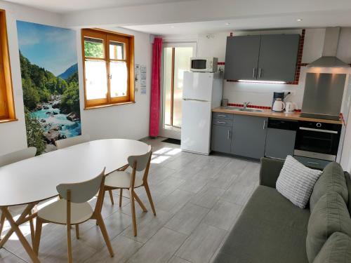a kitchen and living room with a table and chairs at Gîte 829 Montagnes du Jura avec Spa et Sauna classé 3 étoiles in Foncine-le-Haut