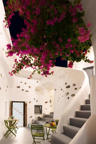 a staircase with pink flowers hanging from the ceiling at Alba Caverns in Fira