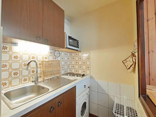 une cuisine avec un évier et une machine à laver dans l'établissement Studio 4 pers, centre village, proche commerces et pistes, TV incluse - FR-1-241-29, au Grand-Bornand