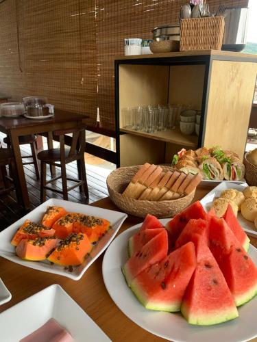 a table with two plates of watermelons and bread at Pousada Rota do Parque in Penha