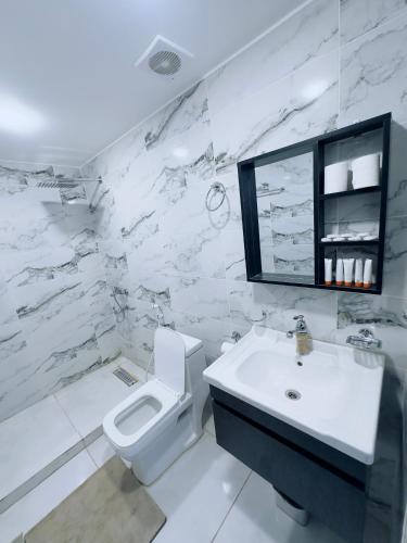 a white bathroom with a toilet and a sink at Rum Kingdom Camp in Wadi Rum